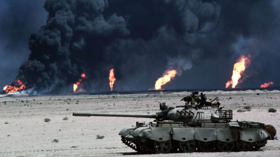 Zniszczony iracki czołg T-55 na tle palących się szybów naftowych