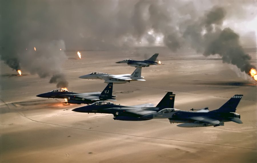 Formacja samolotów F-15 i F-16 nad płonącymi szybami naftowymi