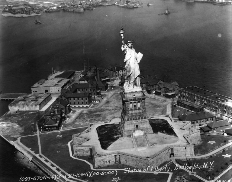 Statua Wolności na Liberty Island w 1927 roku - współcześnie na wyspie nie ma śladu po tych budynkach